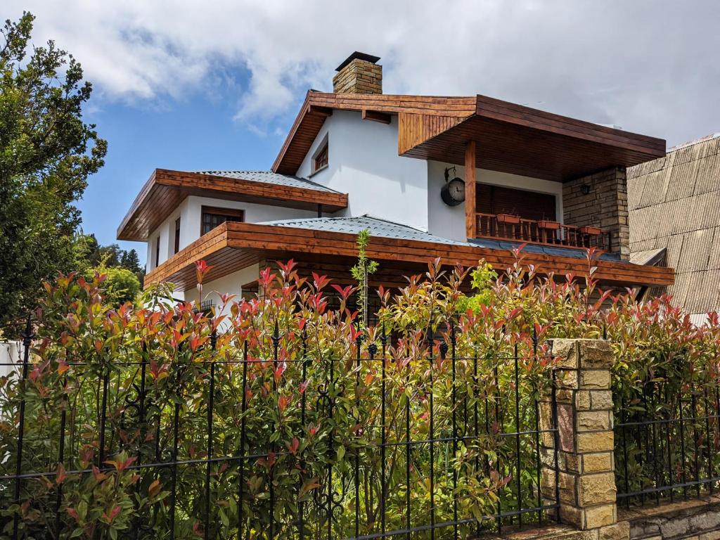 uma casa com uma cerca em frente em Citizen Kane Lodge - Hospedaje Gourmet em San Carlos de Bariloche