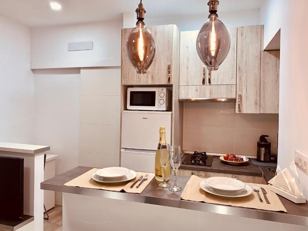 - une cuisine avec une table et une bouteille de vin dans l'établissement Cómodo apartamento en el corazón dé Tenerife, à La Laguna