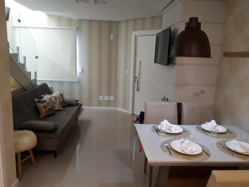 sala de estar con mesa y sofá en Residencial Santa fé flat, en Canela