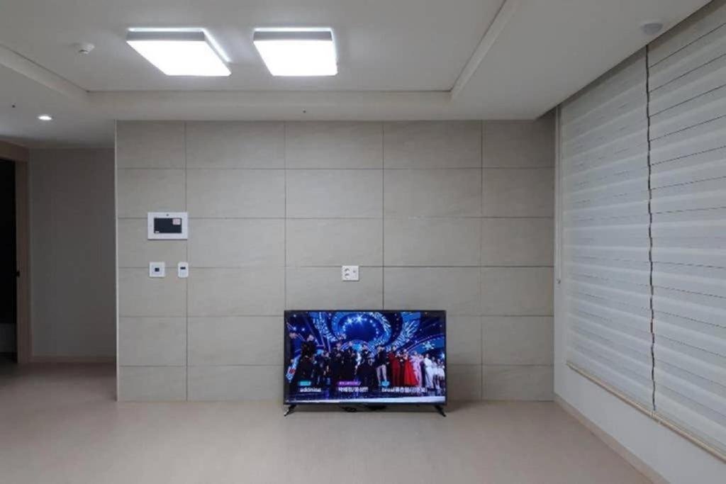 Habitación con TV de pantalla plana en la pared en GOOD VIEW Guest House en Jeonju