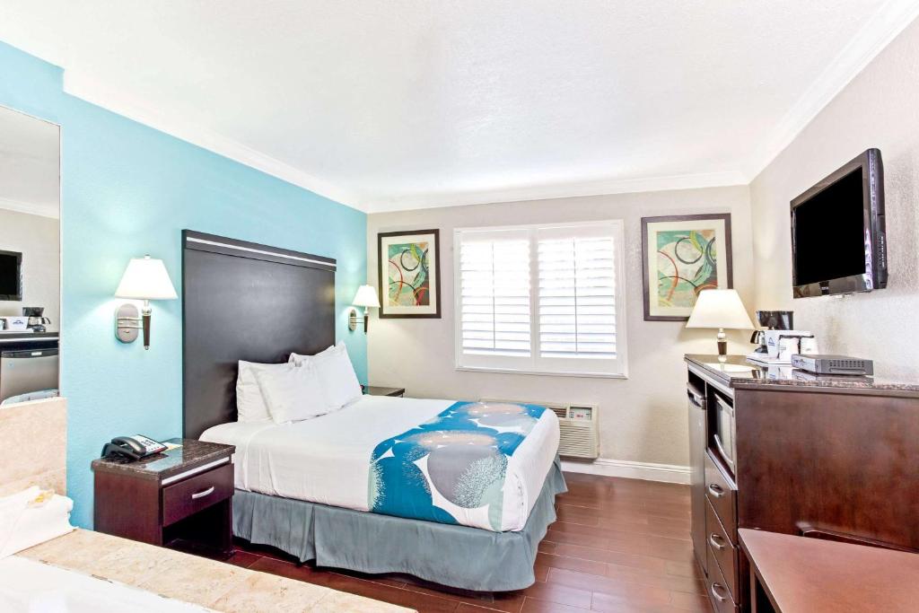 Cabana Inn & Suites في لونغ بيتش: غرفه فندقيه سرير وتلفزيون
