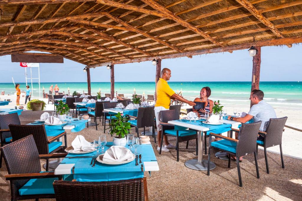 un gruppo di persone seduti ai tavoli sulla spiaggia di Palm Beach Club Marmara Djerba a Midoun