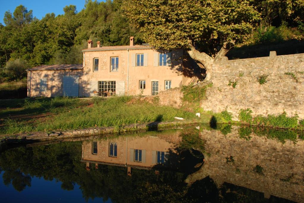 an old house with a reflection in a body of water at Bocage Saint Roman in La Motte