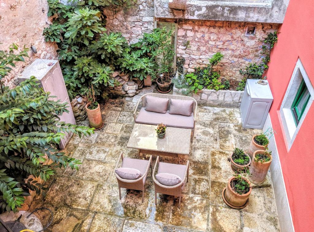 une terrasse avec une table, des chaises et des plantes dans l'établissement Private Courtyard Medieval Stone Home in Old Town, à Rovinj