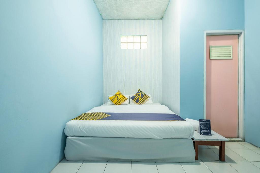 ein Schlafzimmer mit einem Bett in einem blauen Zimmer in der Unterkunft OYO 2384 Pondok Nabil in Tjileunji