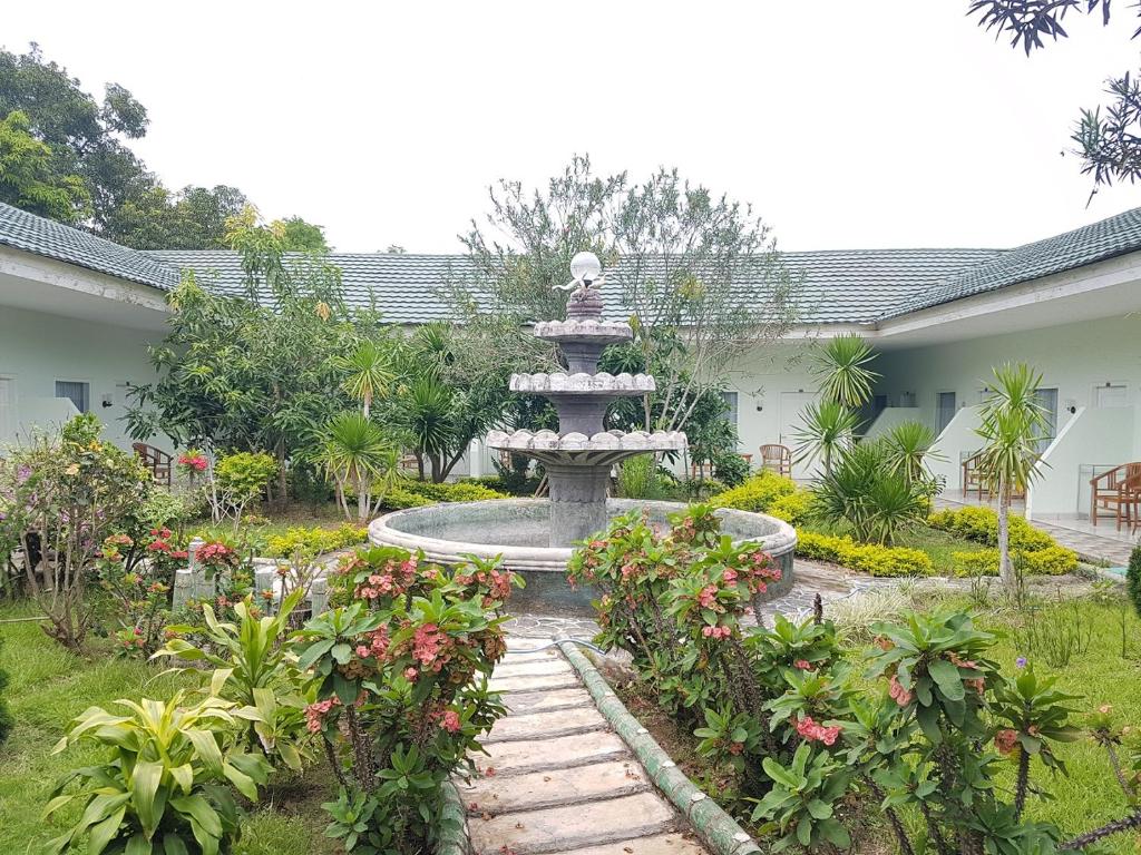 a fountain in the middle of a garden with flowers at Komodo Boutique Hotel in Labuan Bajo