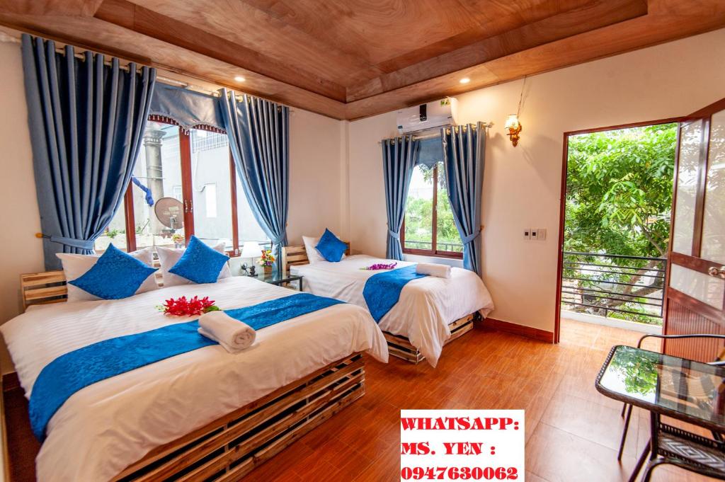 een slaapkamer met 2 bedden en blauwe gordijnen bij Khai Yen Tam Coc Hostel in Ninh Binh