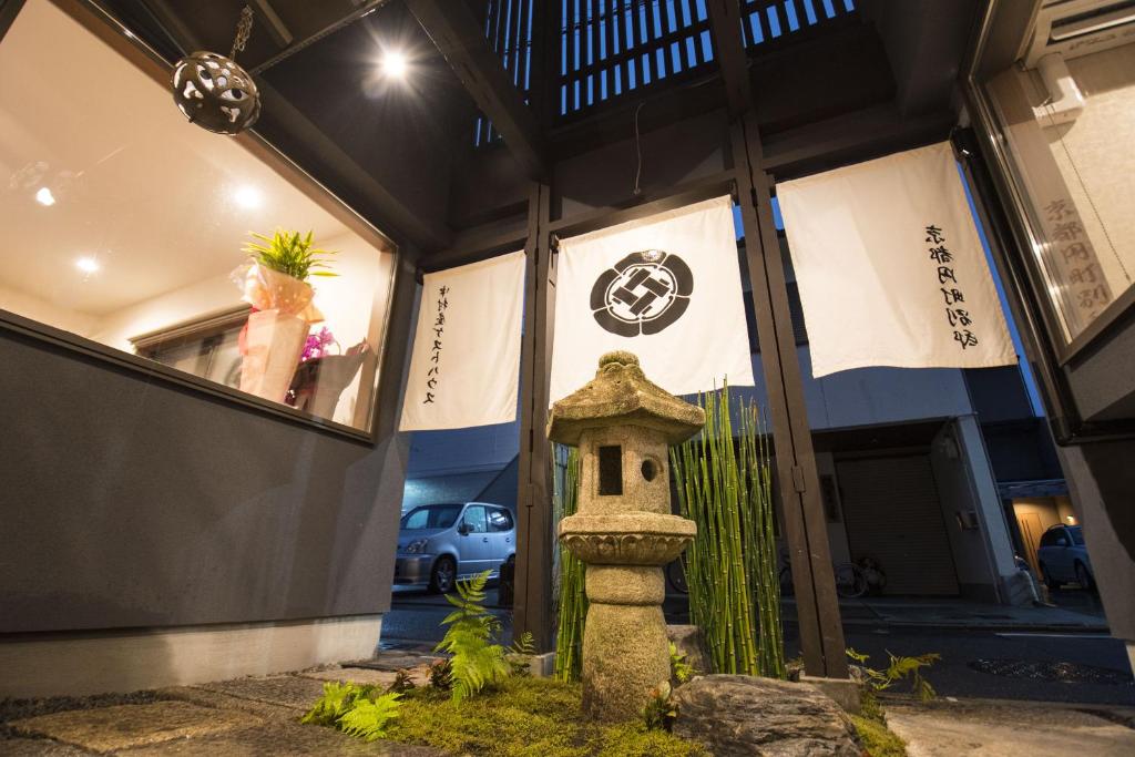 un edificio con una casa de pájaros delante en Nakamuraya Kyoto Enmachi Sakura, en Kioto