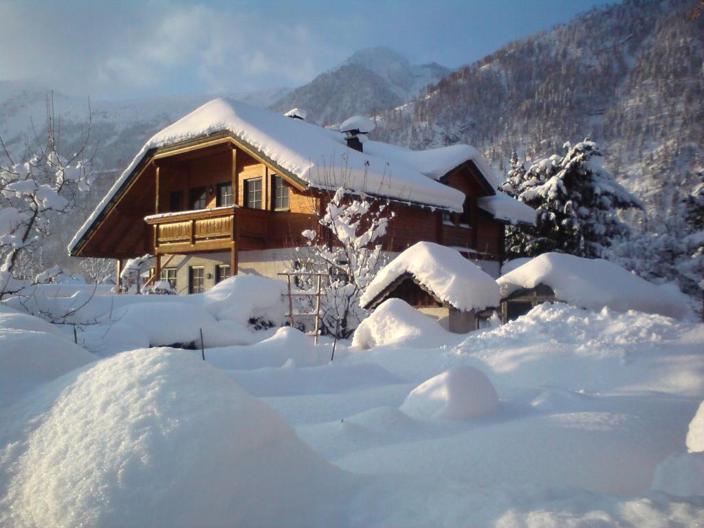 a house covered in snow in front at Ferienwohnung Am Pflanzgarten in Ebensee