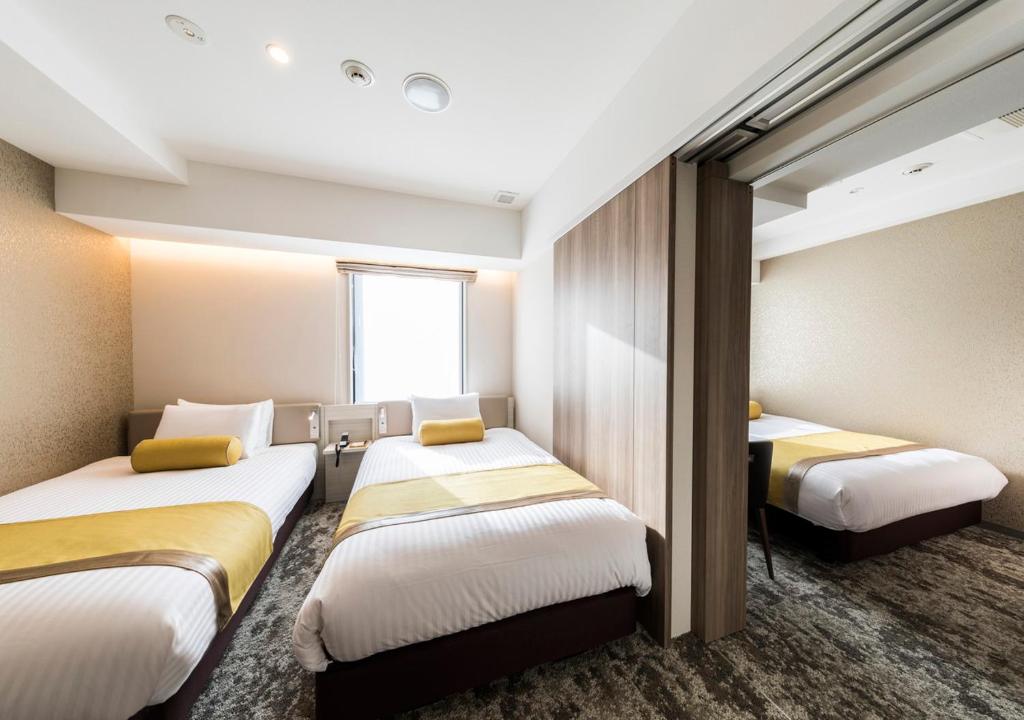 Postel nebo postele na pokoji v ubytování The Rise Osaka Kitashinchi