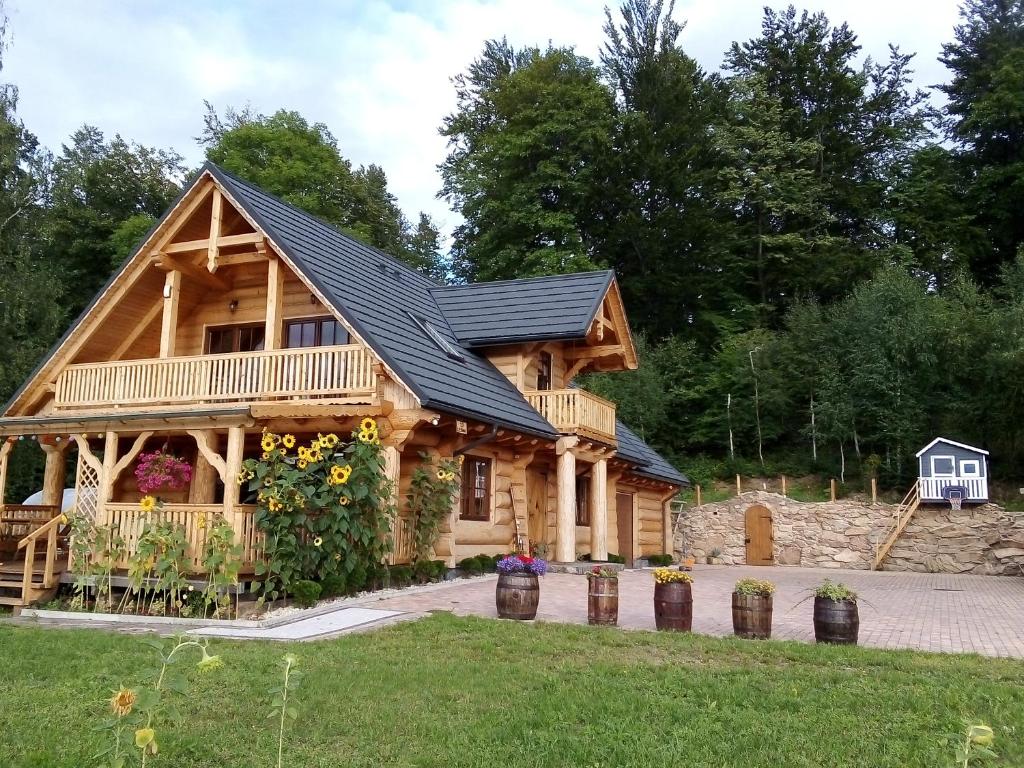 a log cabin with a porch and a balcony at U Janusza i Grażyny in Ściegny