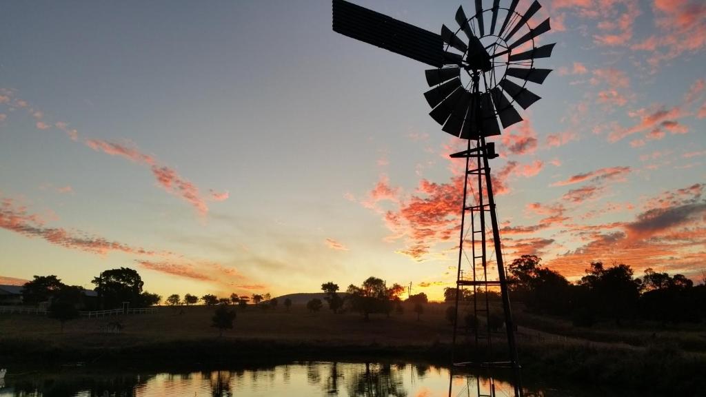 a windmill in a field with the sunset in the background at Milford Country Cottages in Milford