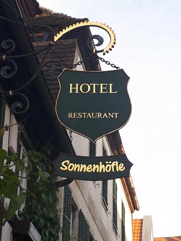 un cartello per un ristorante dell'hotel sul lato di un edificio di Hotel & Restaurant Sonnenhöfle a Sommerhausen