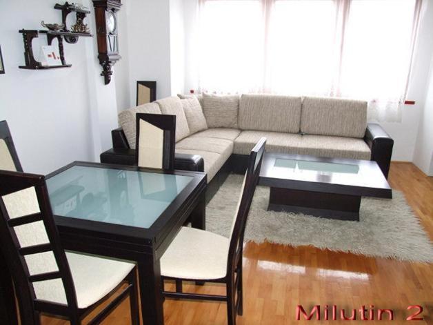 Nikolic Apartments - Ohrid City Centre في أوخريد: غرفة معيشة مع أريكة وطاولة وكراسي