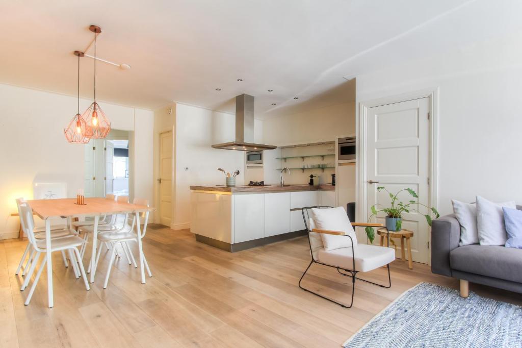 a kitchen and living room with a table and a couch at Luxurious ground floor apartment with patio in Amsterdam