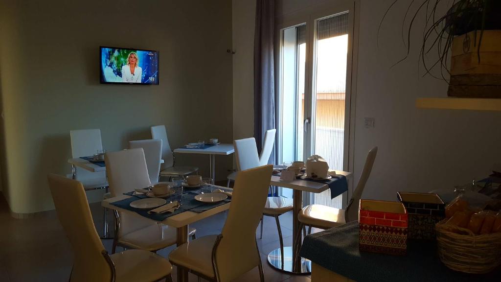 comedor con mesas y sillas y TV en Il Matino, en Leverano