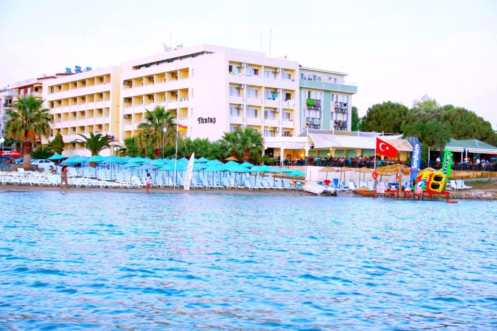 a hotel on the shore of a body of water at Tuntas Beach Hotel - All Inclusive in Didim