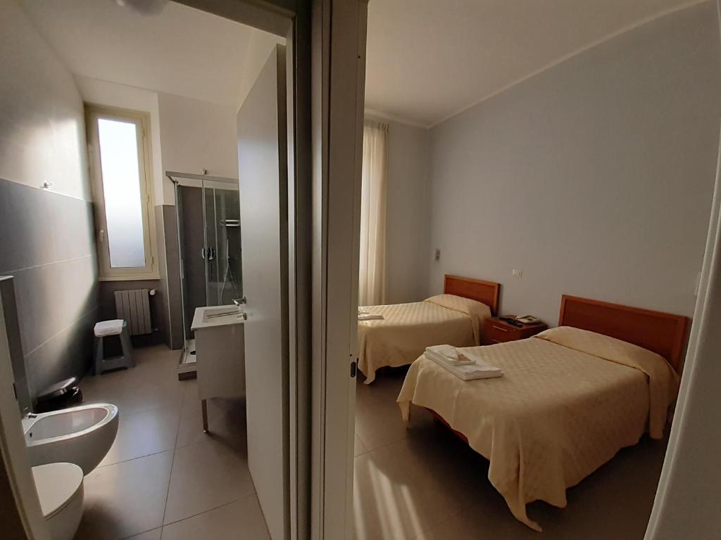a hotel room with two beds and a bathroom at Ostello Villa Monte Mario in Rome