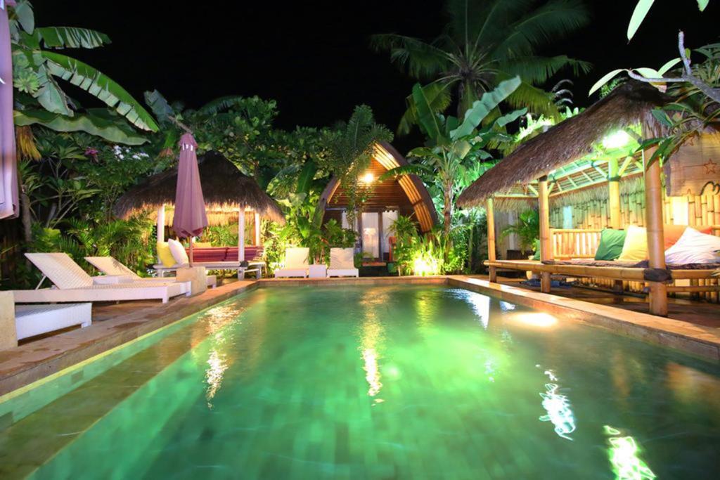 a swimming pool at a resort at night at Unzipp Lumbung Gili Trawangan in Gili Trawangan