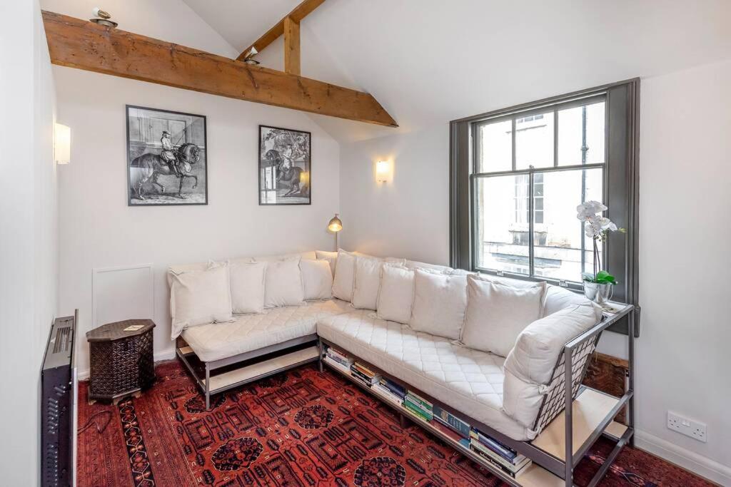 a living room with a white couch and a window at Coachman Cottage, Mews living in Central Bath in Bath