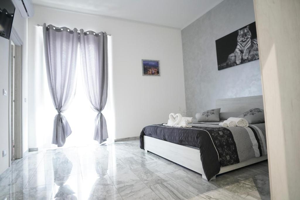 een slaapkamer met een bed en een groot raam bij Central Luxury Apartment in Catania