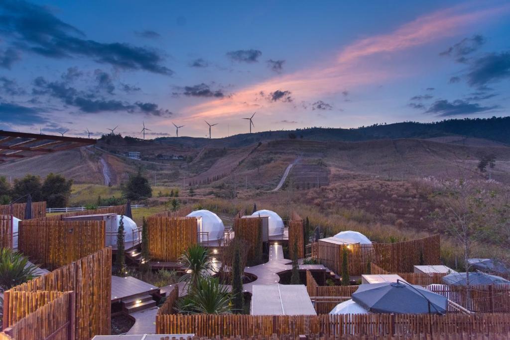 a view of a desert with wind turbines in the distance at Behind Khaokho in Phetchabun