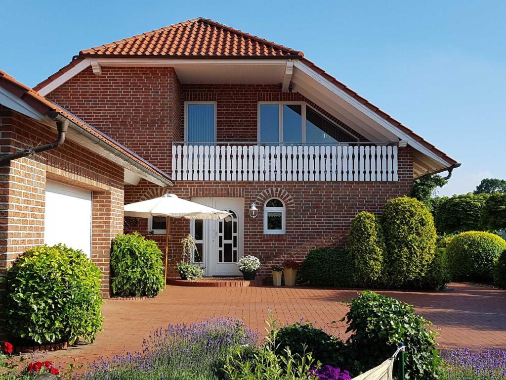 a brick house with an umbrella in front of it at Ferienwohnung Hahn, 95129 in Rhauderfehn