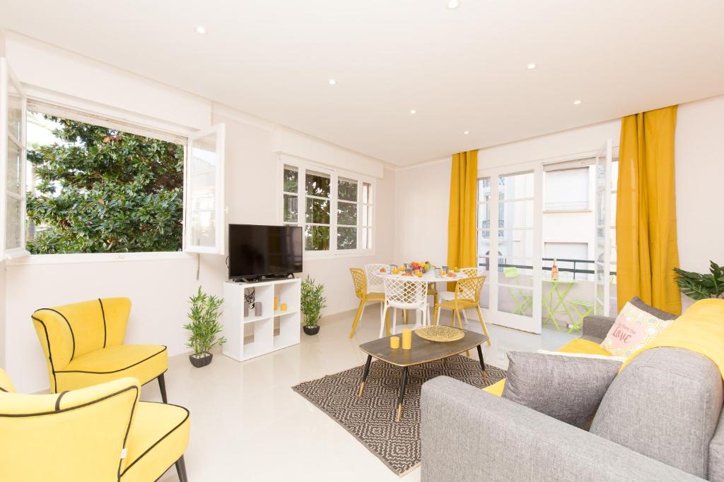un salon avec des chaises jaunes et une table dans l'établissement Festival YourHostHelper, à Cannes