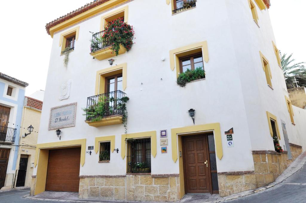 a white building with flower boxes and a door at Casa rural Ravalet 21 in Polop