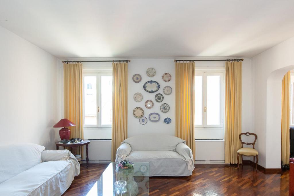 uma sala de estar com um sofá e pratos na parede em Dora Trevi Apartment em Roma