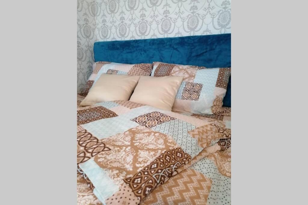 a bed with many different colored pillows on it at Oasis felix apartment in Belgrade