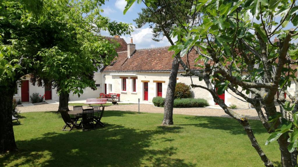 una casa bianca con un tavolo da picnic in un cortile di La Haute Traversiere a Francueil