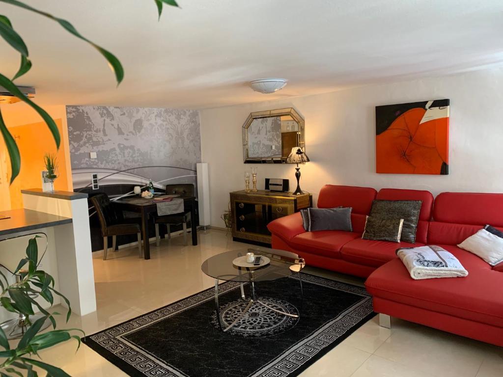 sala de estar con sofá rojo y mesa en Luxus Domizil, en Villingen-Schwenningen