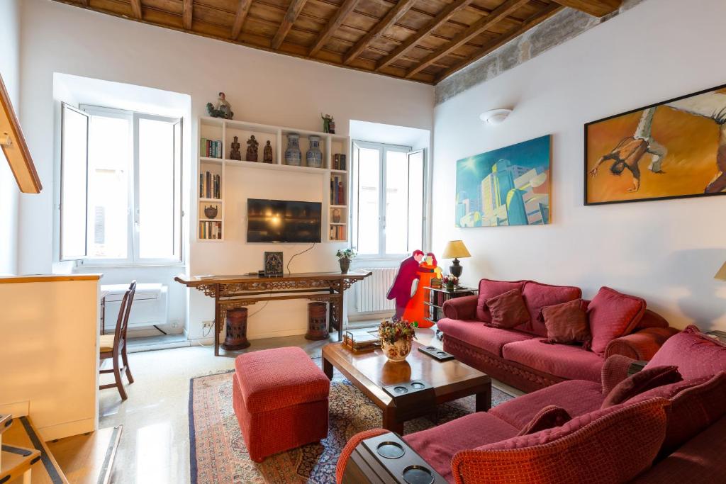 un soggiorno con divano rosso e tavolo di Savelli Apartment a Roma