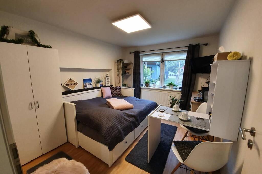 a small room with a bed and a desk at Zentrales Zimmer auf dem Land in Großsolt