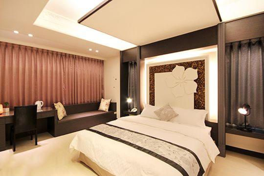 una camera con un grande letto e una scrivania di Lo Hong ka Countryside House a Luodong
