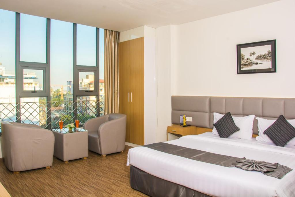 a hotel room with a bed and a balcony at Botahtaung Hotel in Yangon