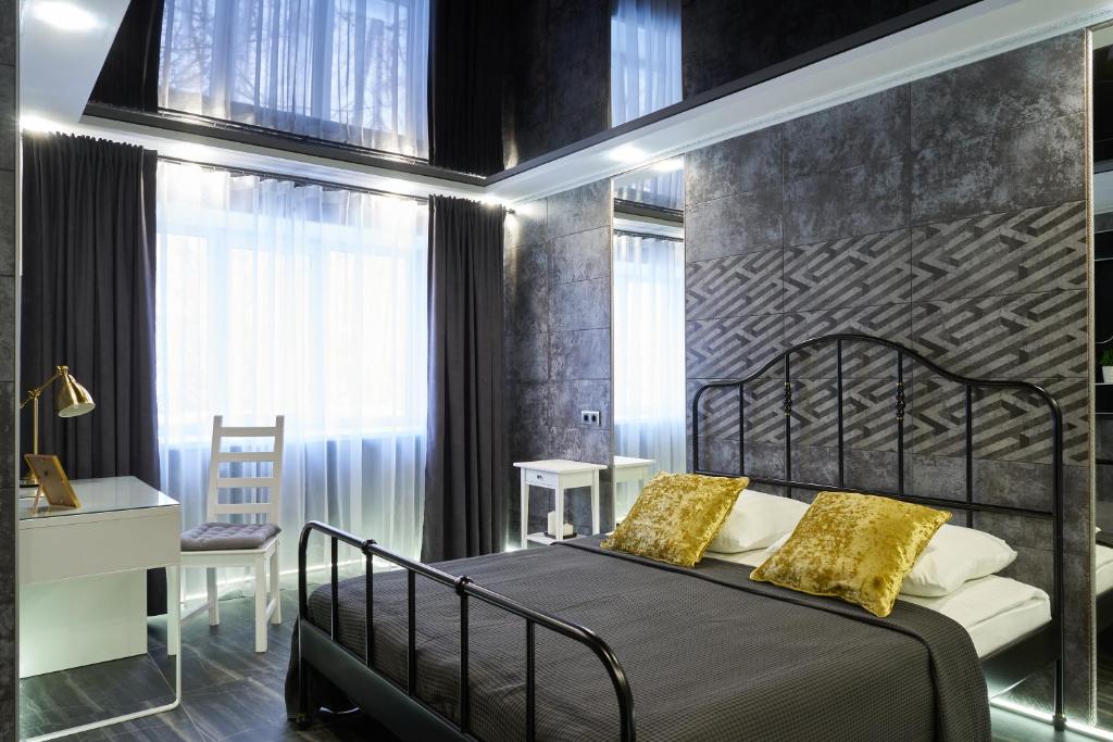 a bedroom with a black bed with yellow pillows at "GOOD NIGHT" on Kotovskogo 28 in Tomsk