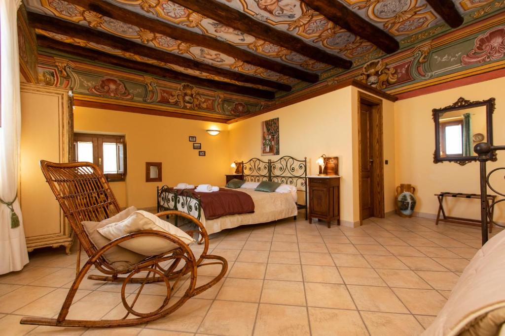 a bedroom with a bed and a chair in a room at Palazzo Lauritano in Agerola