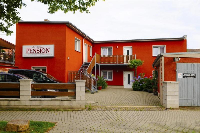 - un bâtiment rouge avec un parking en face dans l'établissement Grochlitzer Pension, à Naumbourg