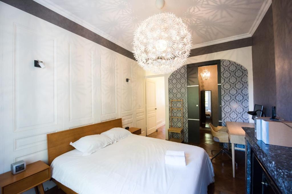 リヨンにあるCharmant appartement tout confort 134 Thiers - Lyon 6eのベッドルーム(白いベッド1台、シャンデリア付)