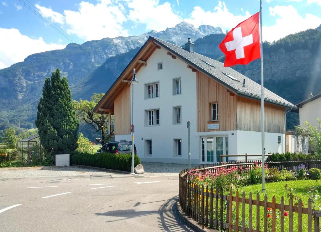 ein Haus mit einer Schaukelflagge davor in der Unterkunft Mountain-Panorama in Meiringen