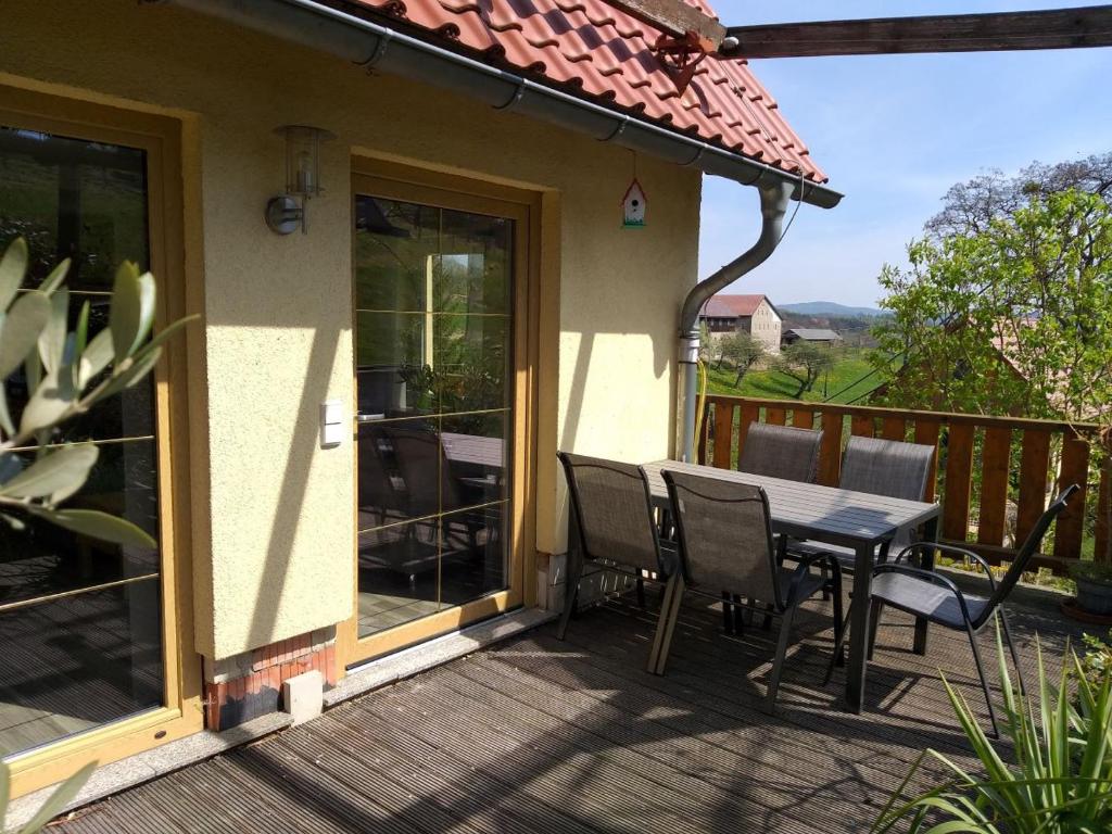 a patio with a table and chairs on a deck at Ferienappartment Henke in Hohnstein
