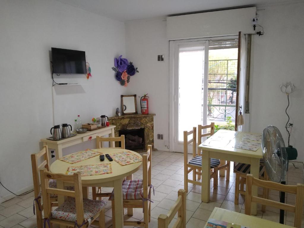 a kitchen with two tables and chairs and a fireplace at Lo de Pablo in Vicente López