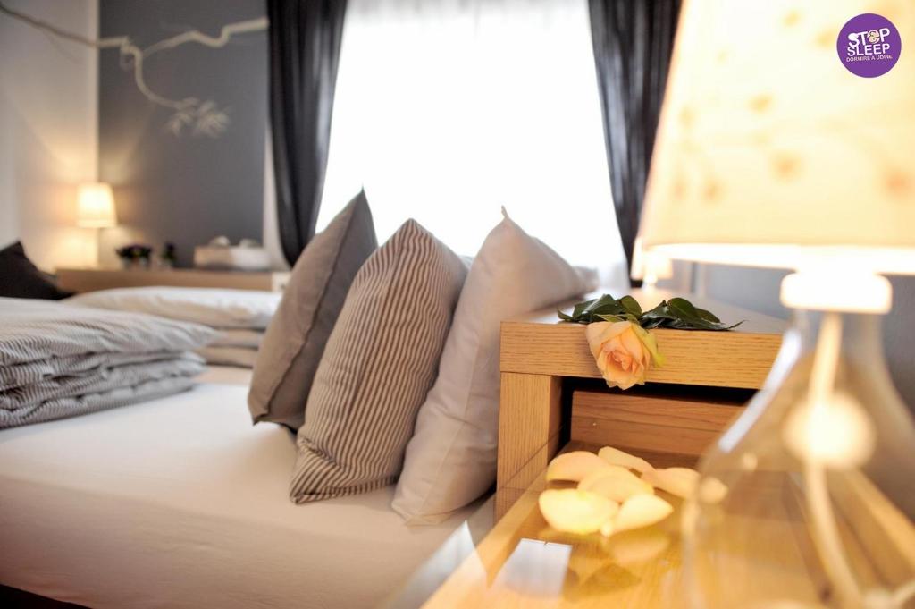 a bedroom with a bed with pillows and a table at Stop & Sleep Udine in Udine