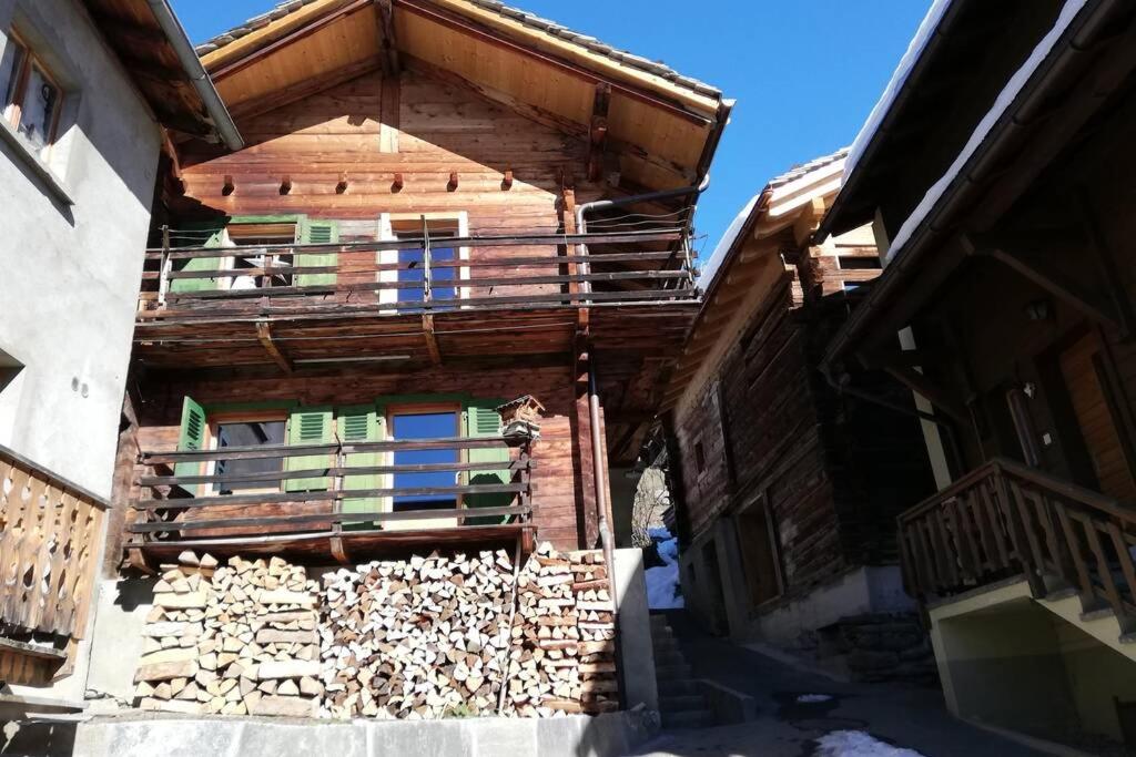 a wooden house with a pile of fire wood at Chalet 3 chambres à Sarreyer, proche Verbier in Sarreyer