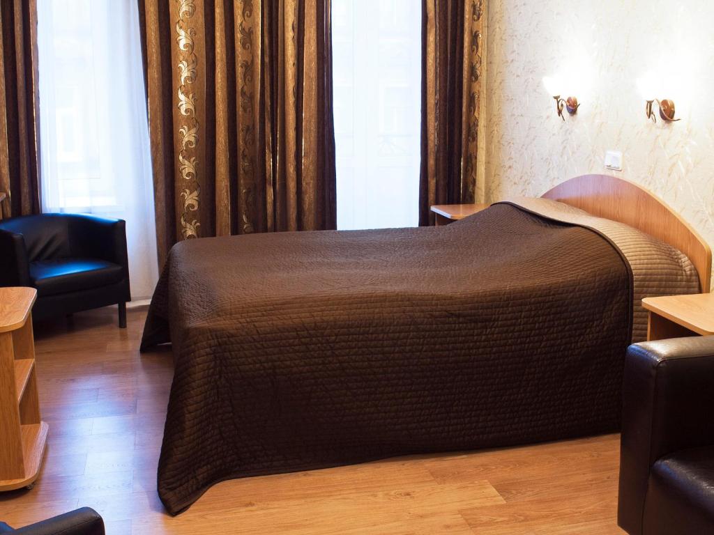 1 dormitorio con 1 cama con colcha marrón en Hotel Akvareli Vosstaniya, en San Petersburgo