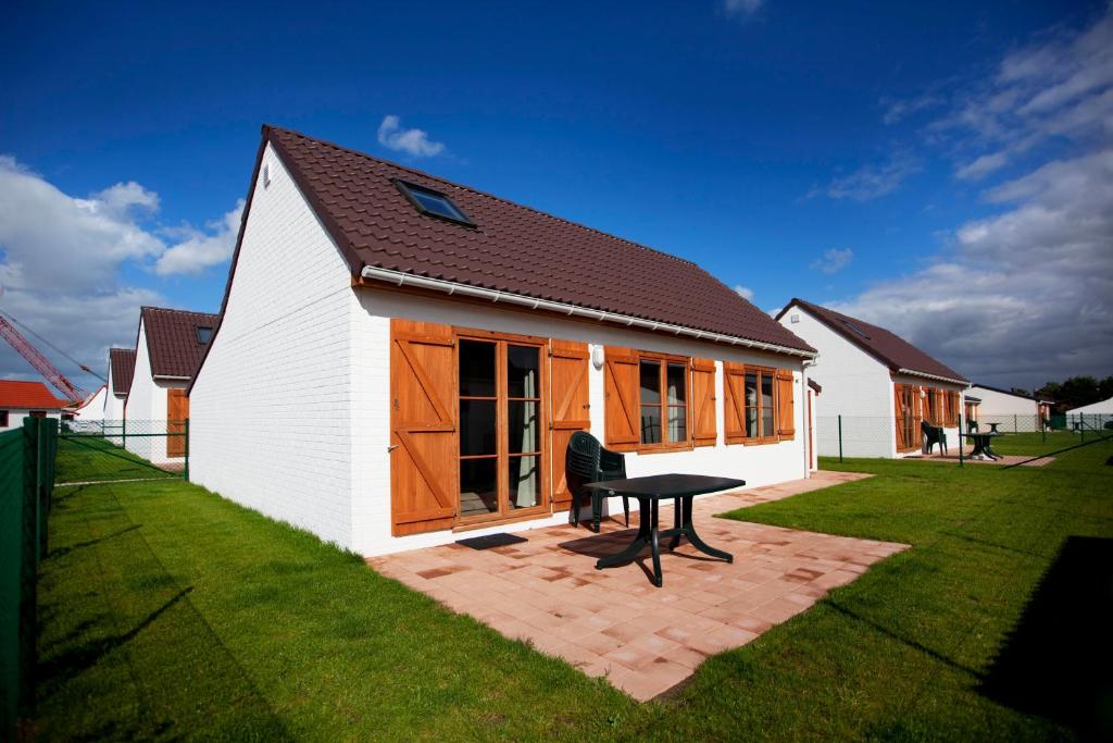 une maison avec une table de pique-nique dans une cour dans l'établissement Zeepark Haerendycke, à Wenduine