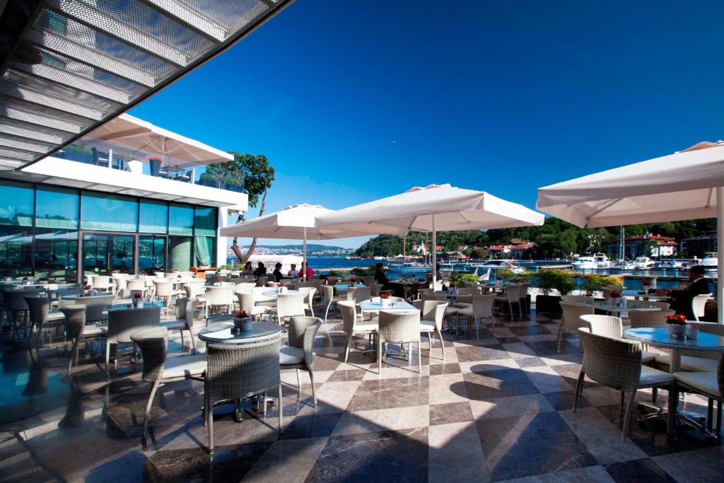 a restaurant with tables and chairs and umbrellas at The Grand Tarabya Managed by Accor in Istanbul