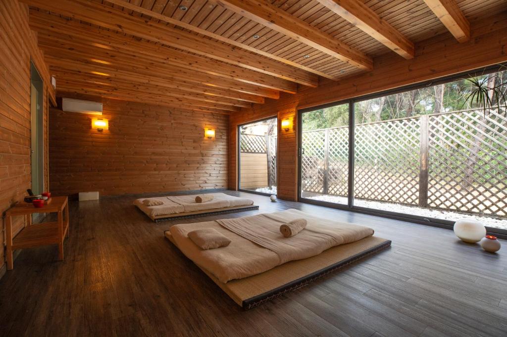 two beds in a large room with large windows at Hotel Santa Marta in Lloret de Mar